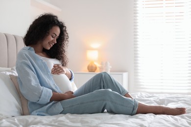 Portrait of beautiful pregnant woman on bed at home