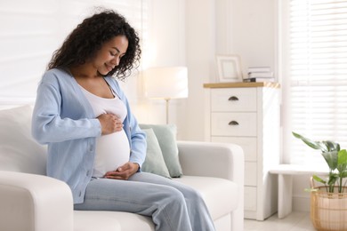 Photo of Portrait of beautiful pregnant woman on sofa at home