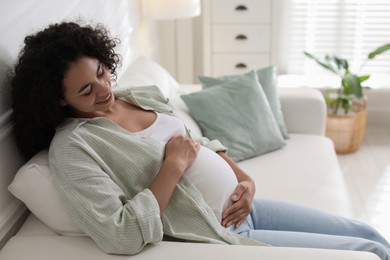 Photo of Portrait of beautiful pregnant woman on sofa at home