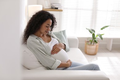 Photo of Portrait of beautiful pregnant woman on sofa at home