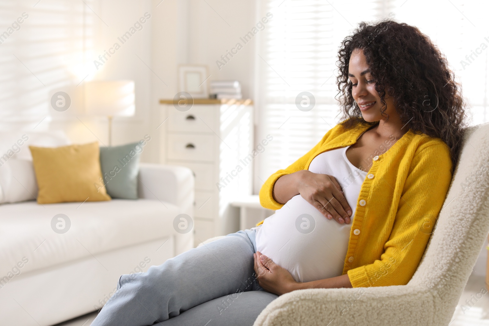 Photo of Portrait of beautiful pregnant woman in armchair at home