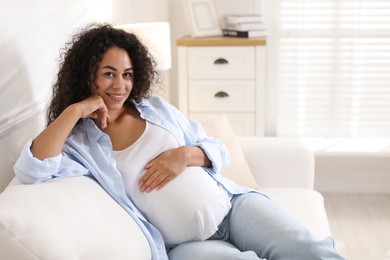 Photo of Portrait of beautiful pregnant woman on sofa at home