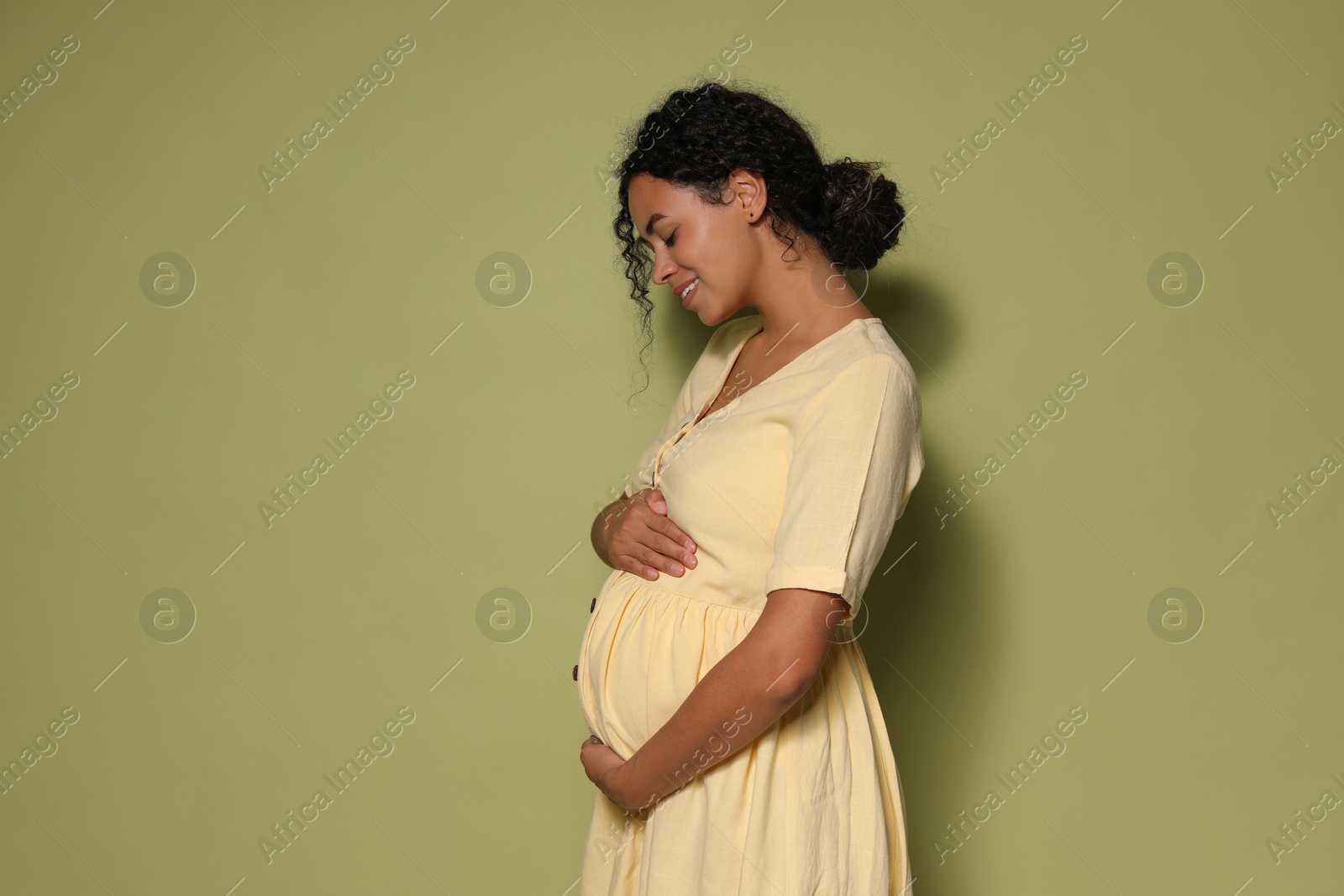 Photo of Portrait of beautiful pregnant woman on green background