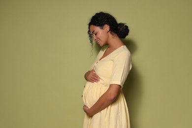 Portrait of beautiful pregnant woman on green background