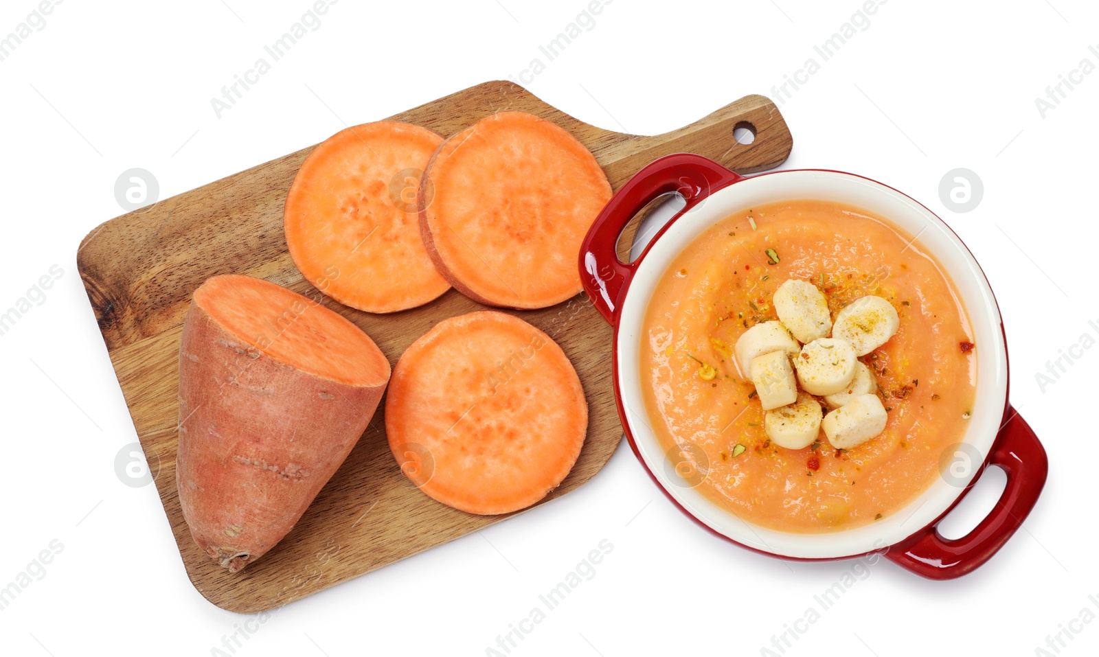 Photo of Delicious sweet potato soup with croutons and fresh vegetable isolated on white, top view