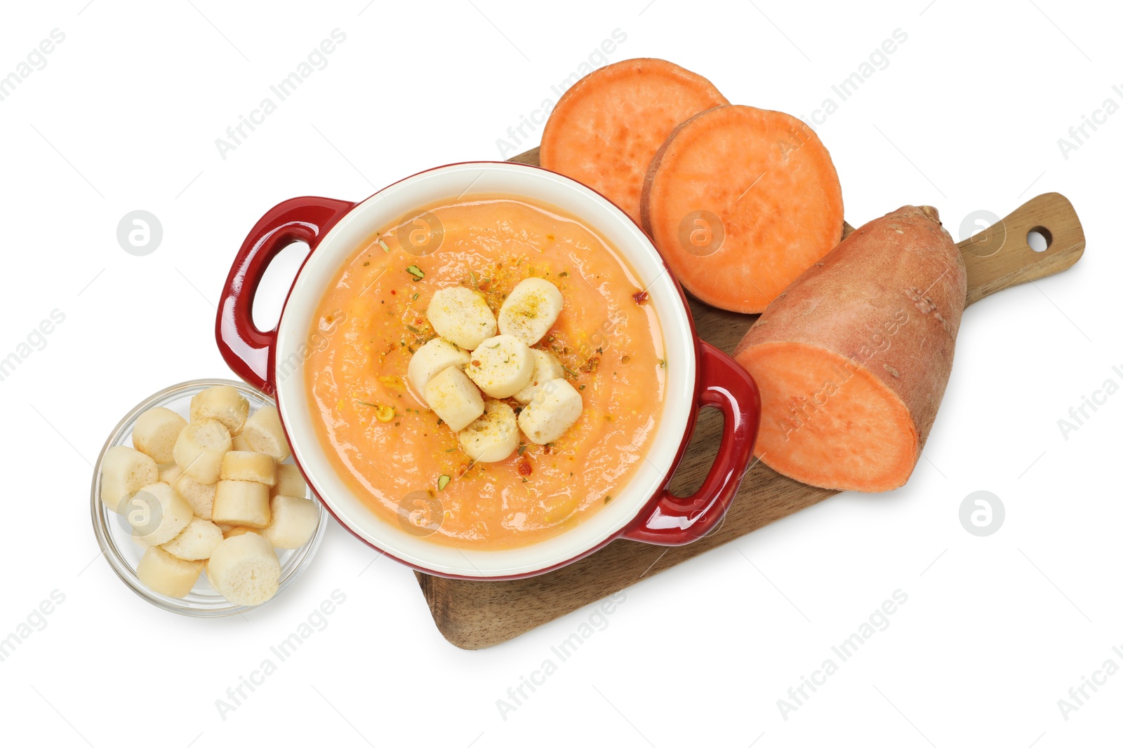 Photo of Delicious sweet potato soup with croutons and fresh vegetable isolated on white, top view