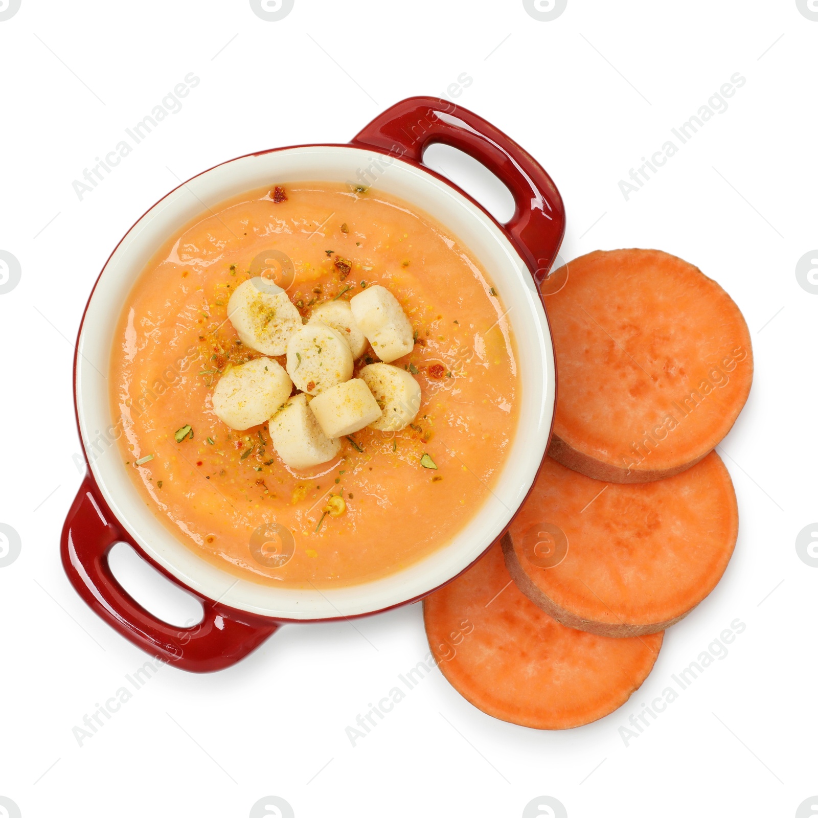 Photo of Delicious sweet potato soup with croutons and fresh vegetable isolated on white, top view