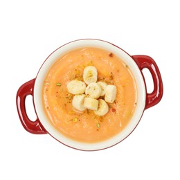 Photo of Delicious sweet potato soup with croutons isolated on white, top view