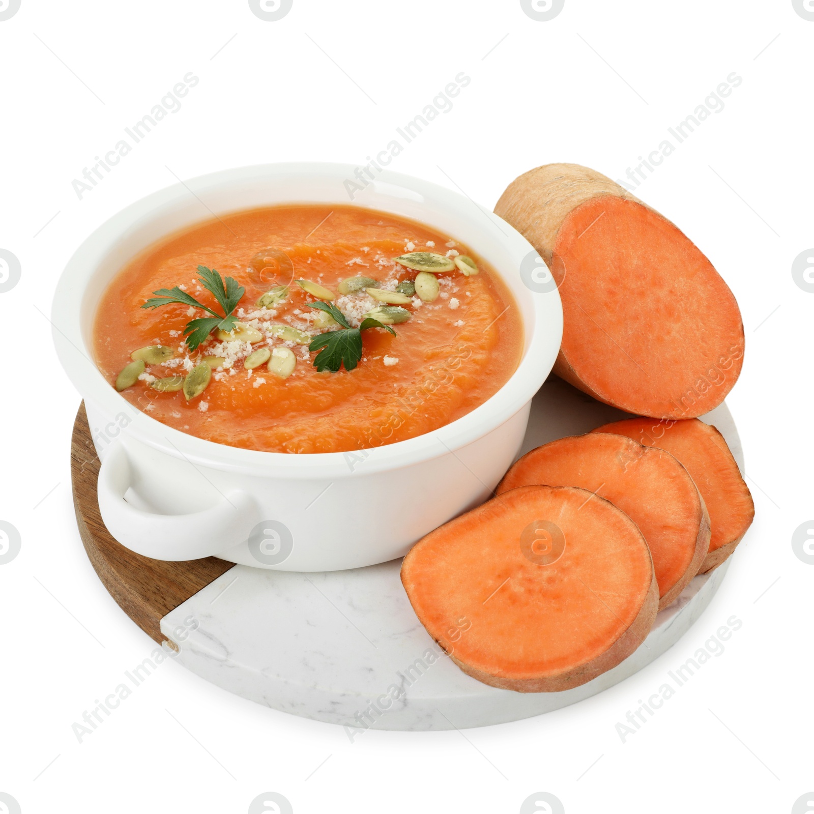 Photo of Delicious sweet potato soup with pumpkin seeds in bowl and fresh vegetable isolated on white