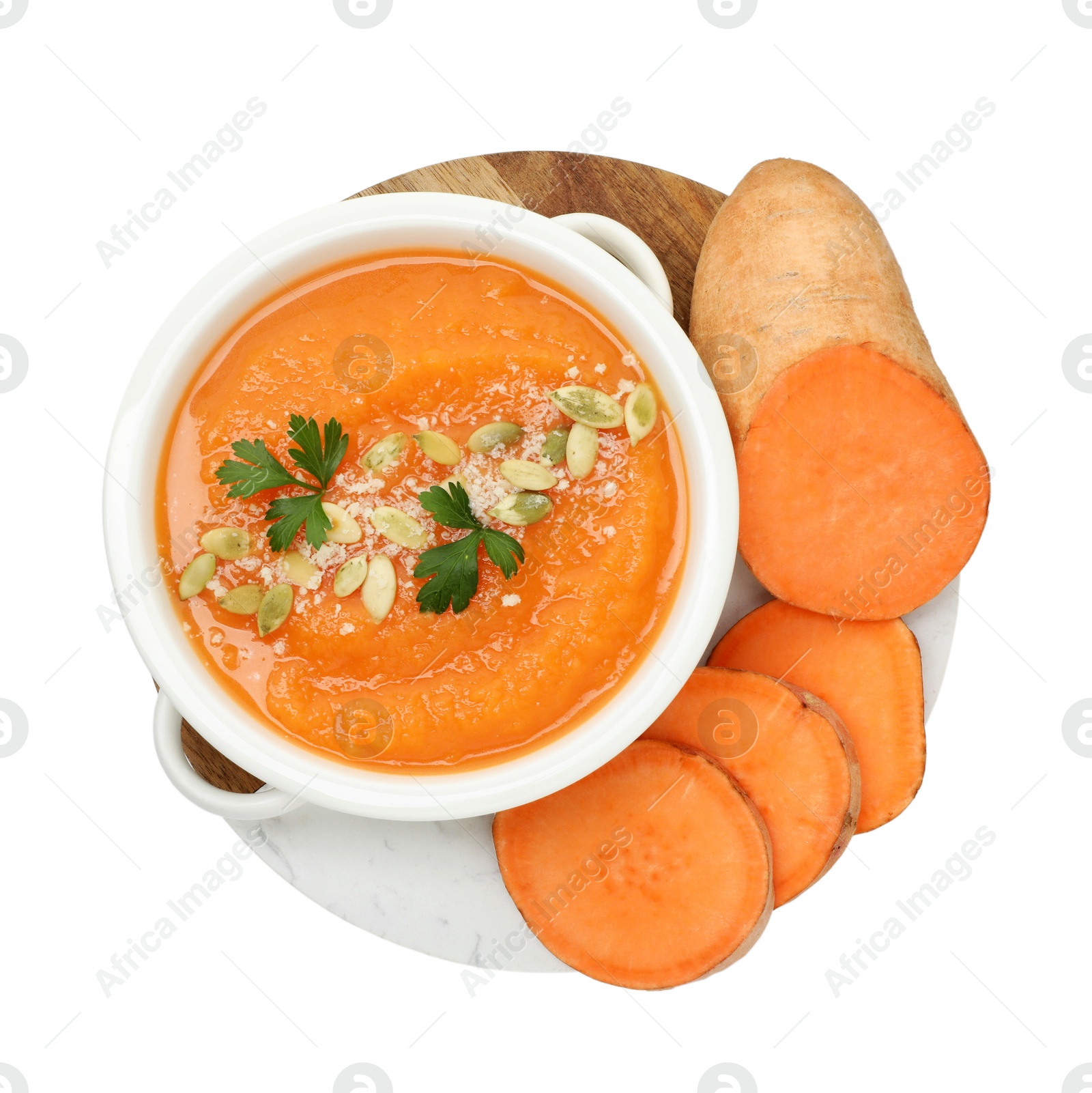 Photo of Delicious sweet potato soup with pumpkin seeds in bowl and fresh vegetable isolated on white, top view