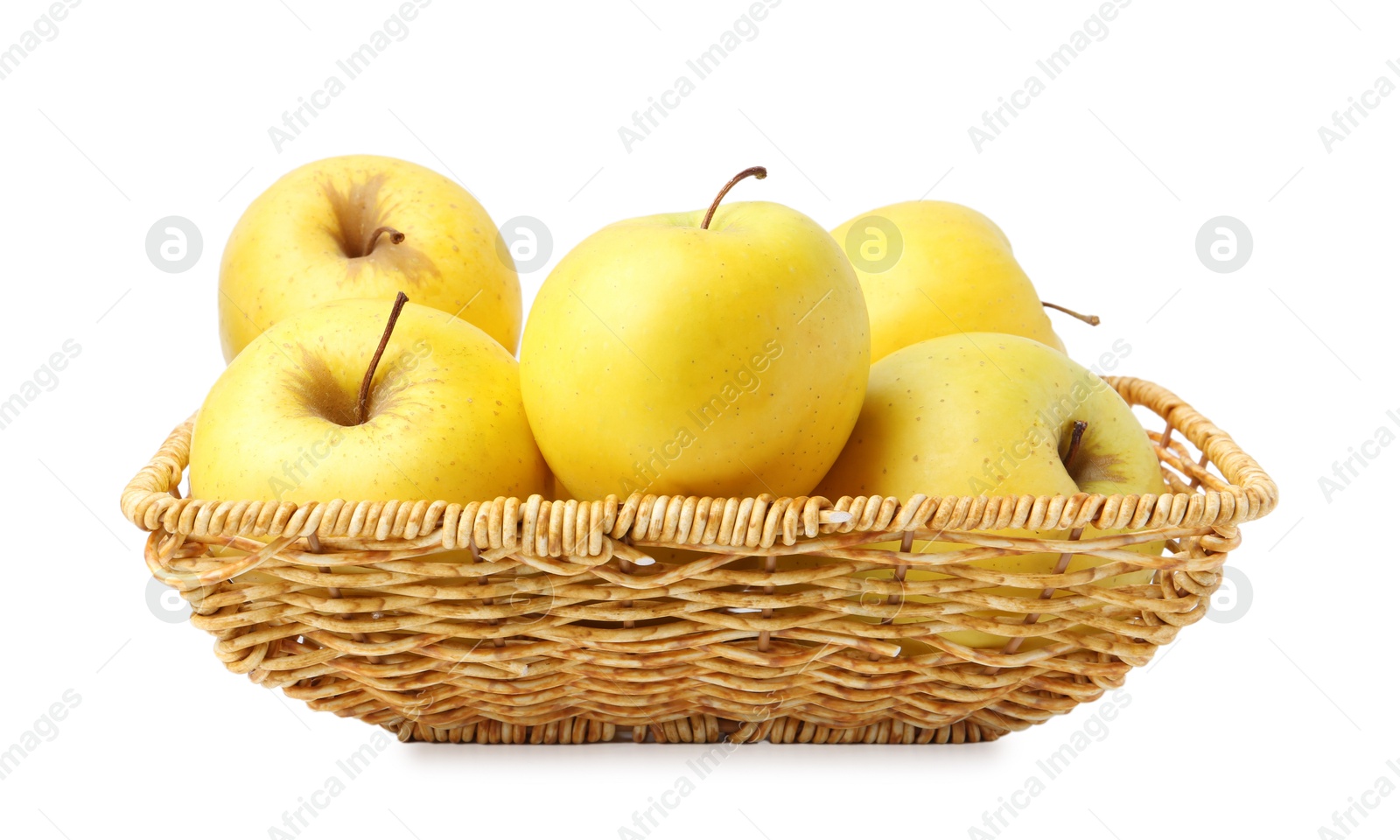 Photo of Many fresh yellow apples in wicker basket isolated on white