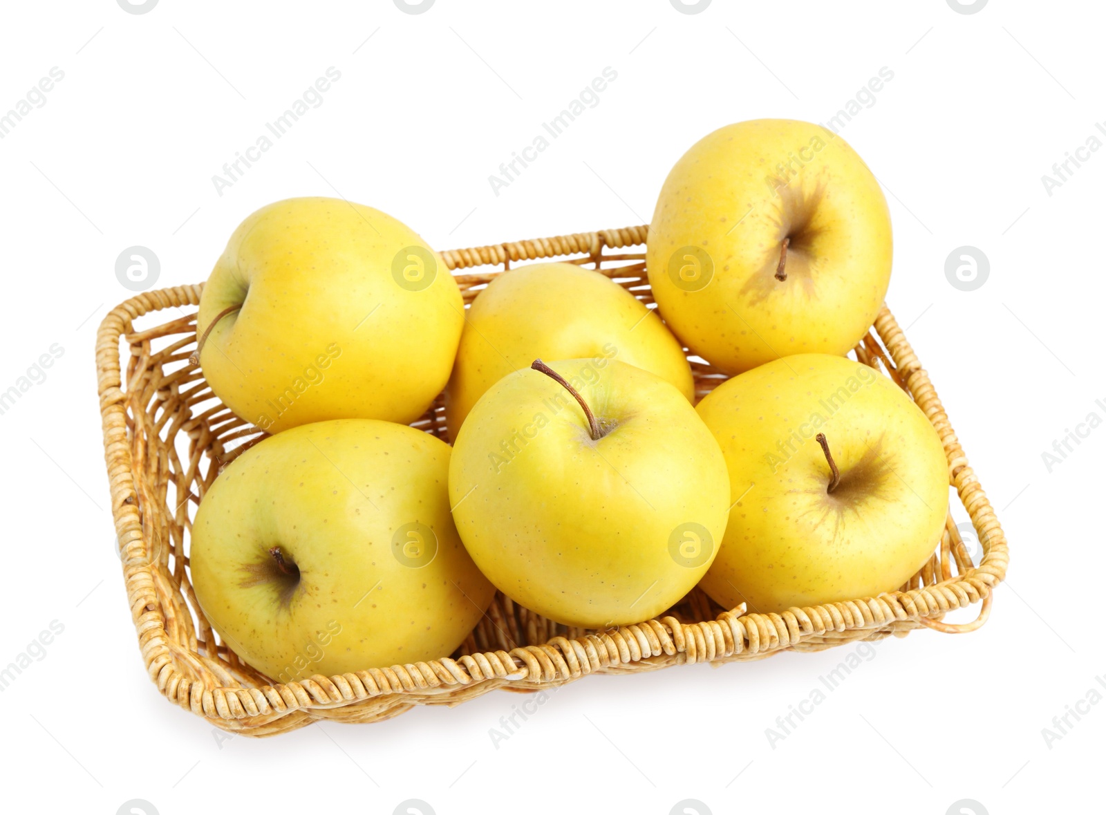 Photo of Many fresh yellow apples in wicker basket isolated on white