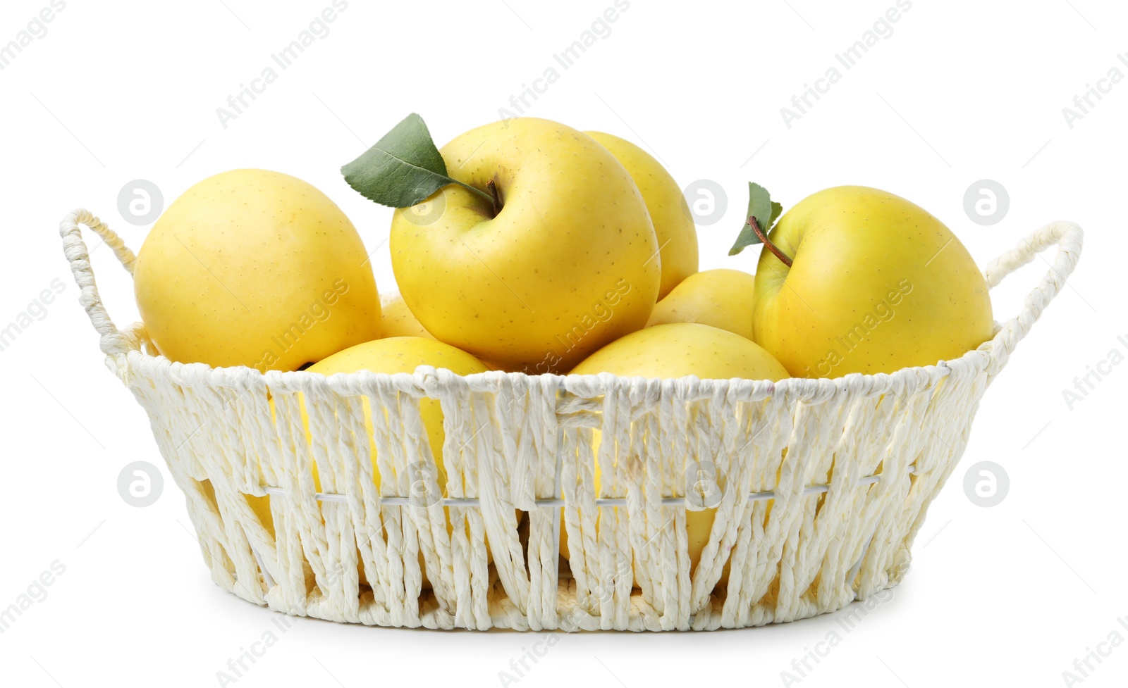 Photo of Many fresh yellow apples in wicker basket isolated on white