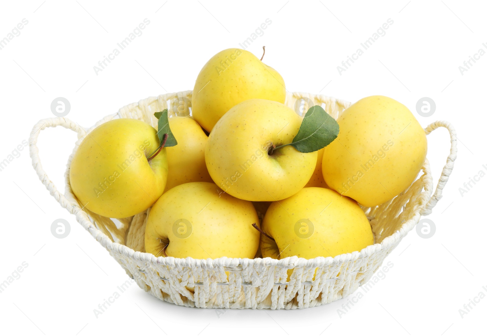 Photo of Many fresh yellow apples in wicker basket isolated on white