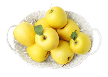 Photo of Many fresh yellow apples in wicker basket isolated on white, top view