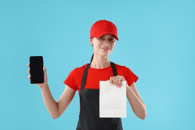 Photo of Fast-food worker with paper bag and smartphone on light blue background