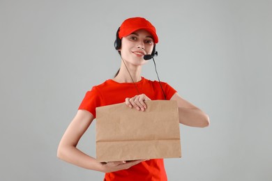 Photo of Fast-food worker with paper bag on gray background