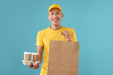 Fast-food worker with paper bag and cups on light blue background