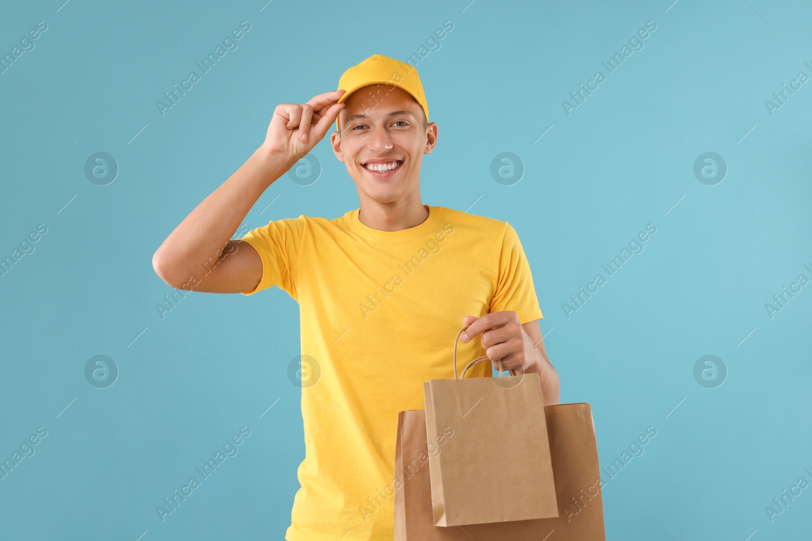 Photo of Fast-food worker with paper bags on light blue background