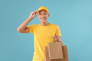 Fast-food worker with paper bags on light blue background