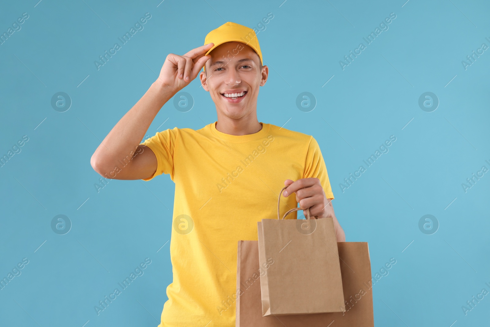 Photo of Fast-food worker with paper bags on light blue background