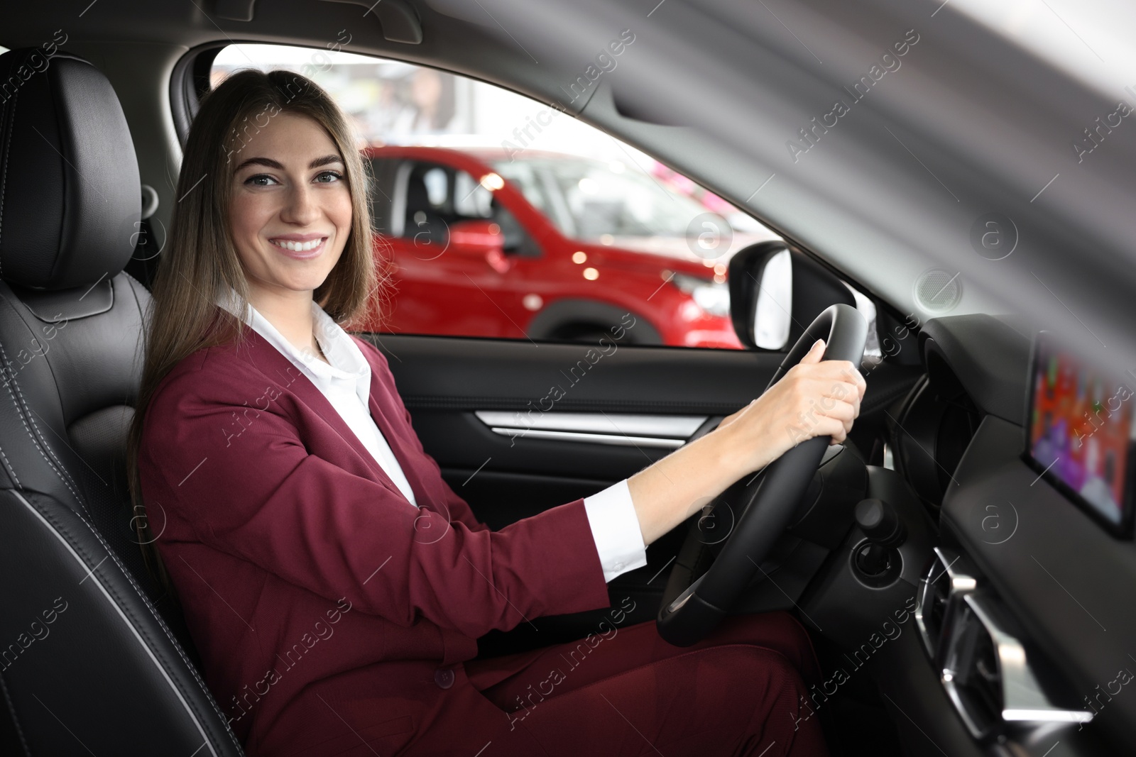 Photo of Young woman inside new car in salon