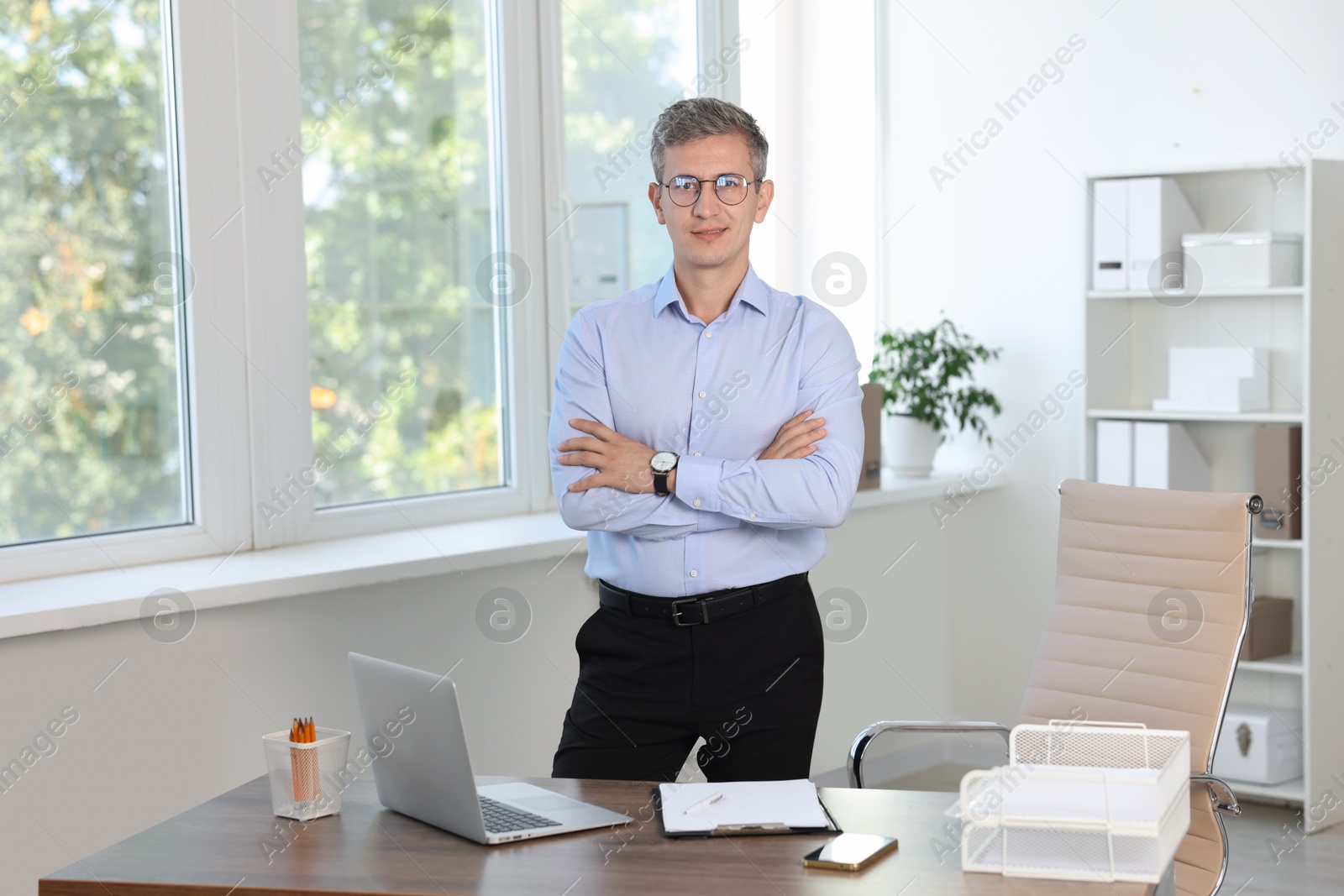 Photo of Portrait of middle aged man with crossed arms in office