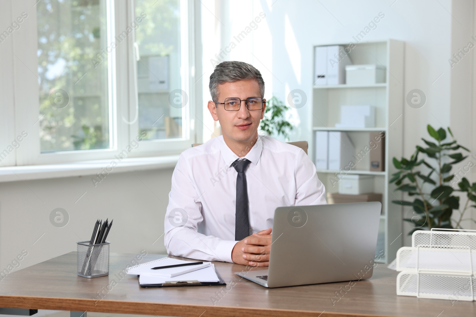 Photo of Portrait of middle aged man at table in office