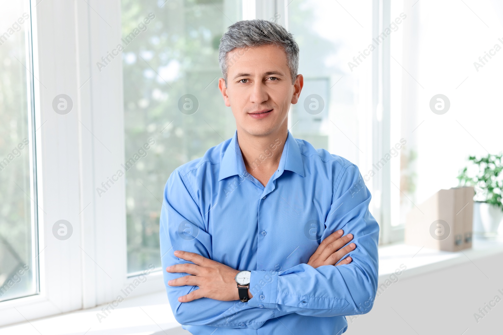 Photo of Portrait of middle aged man with crossed arms in office