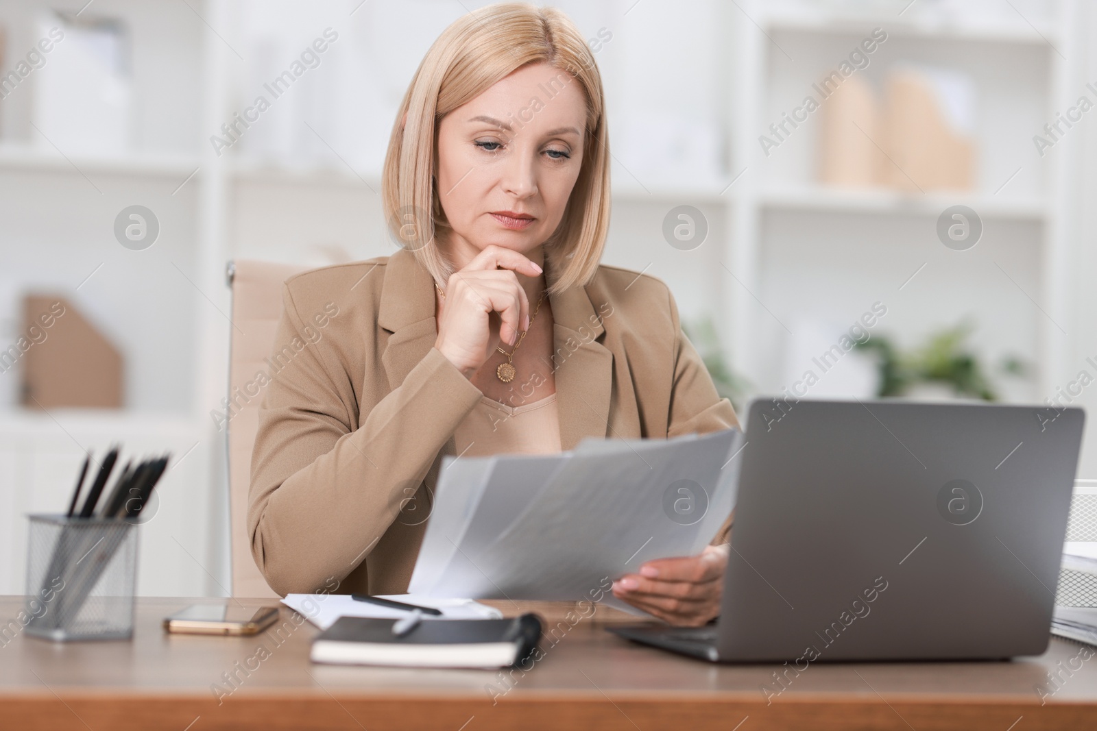 Photo of Middle aged woman working at table in office