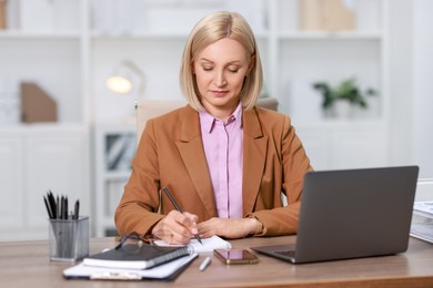 Middle aged woman working at table in office