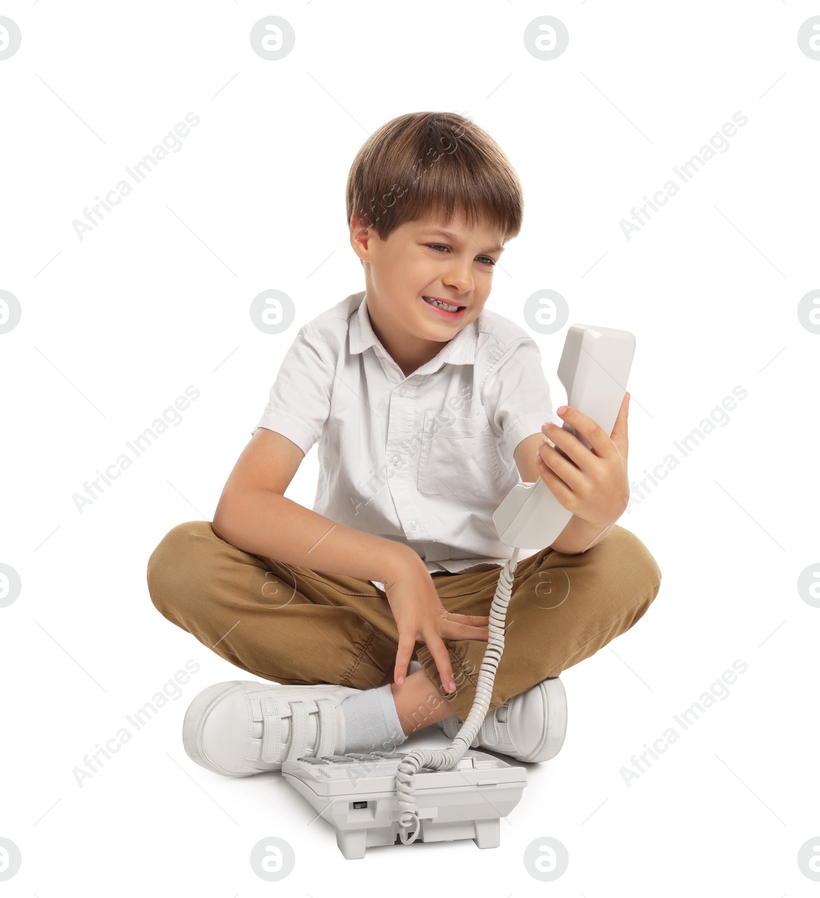 Photo of Cute little boy with telephone on white background