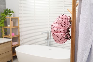 Shower cap and towel on rack in bathroom, space for text