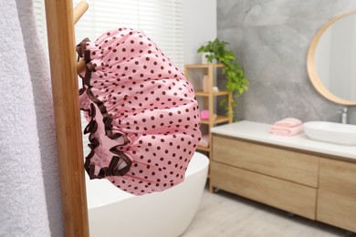 Photo of Shower cap and towel on rack in bathroom