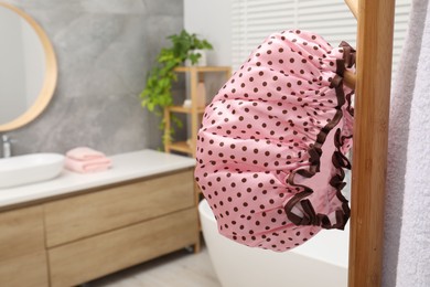 Shower cap and towel on rack in bathroom