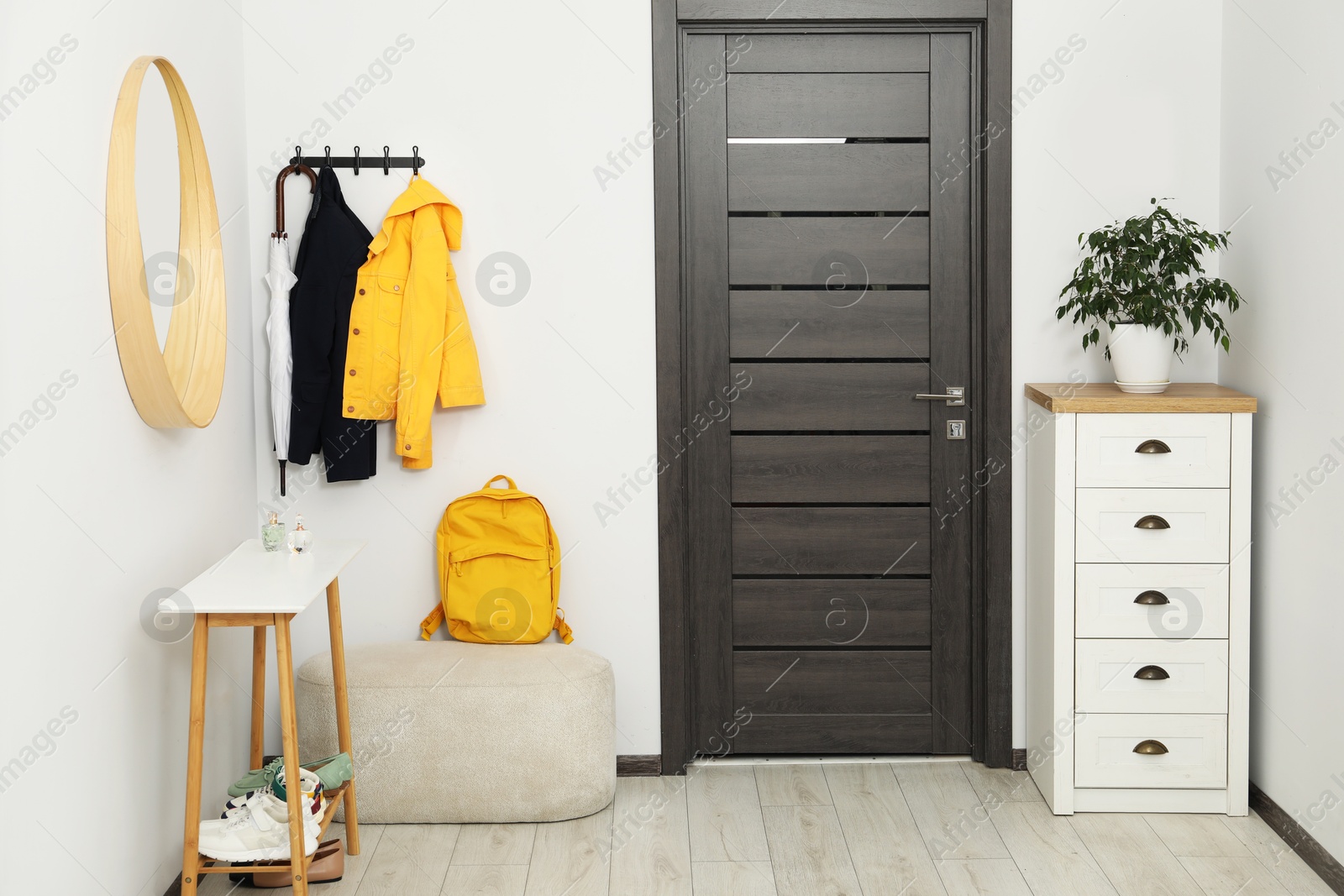 Photo of Mirror, rack with clothes, chest of drawers and shoe storage bench in hallway. Interior design