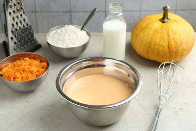 Photo of Bowl with dough and ingredients for pumpkin pancakes on light table