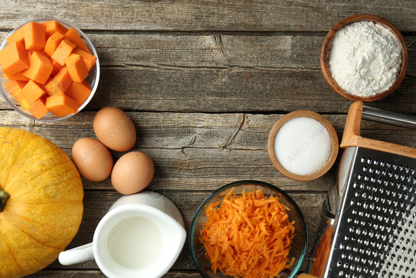 Photo of Different ingredients for pumpkin pancakes on wooden table, flat lay. Space for text