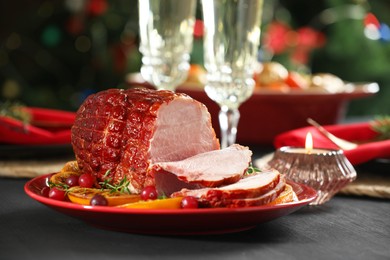 Photo of Tasty baked ham served on black wooden table, closeup