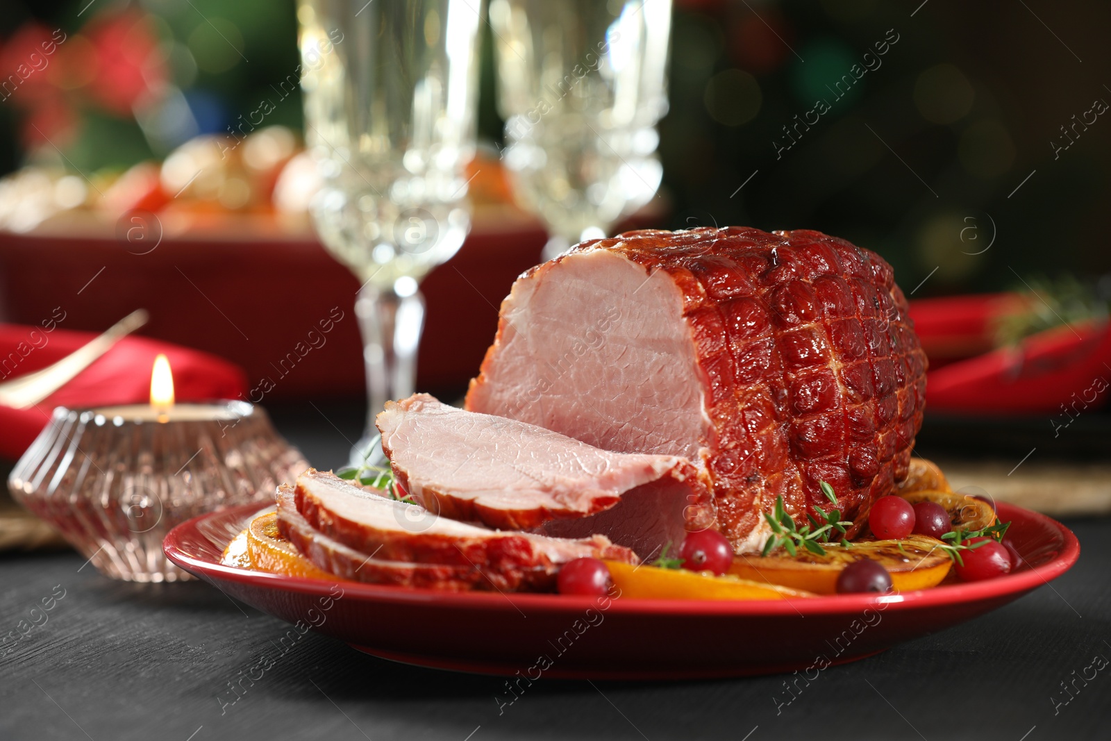 Photo of Tasty baked ham served on black wooden table, closeup