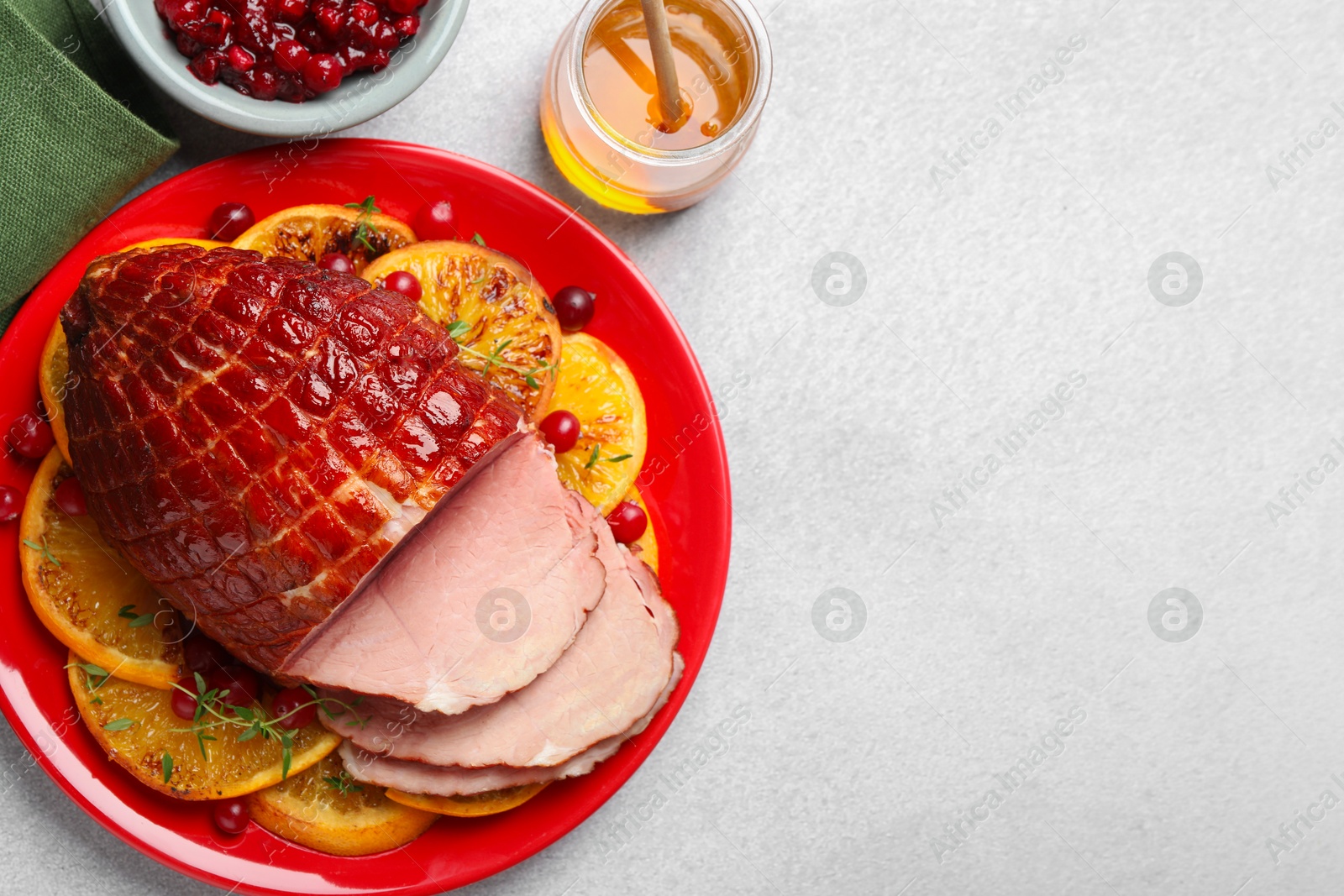 Photo of Tasty baked ham served on white table, flat lay. Space for text