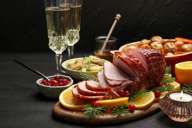 Photo of Tasty baked ham served on black wooden table