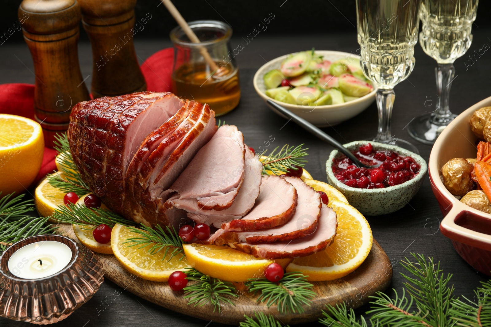 Photo of Tasty baked ham served on black wooden table