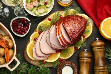 Photo of Tasty baked ham served on black wooden table, flat lay