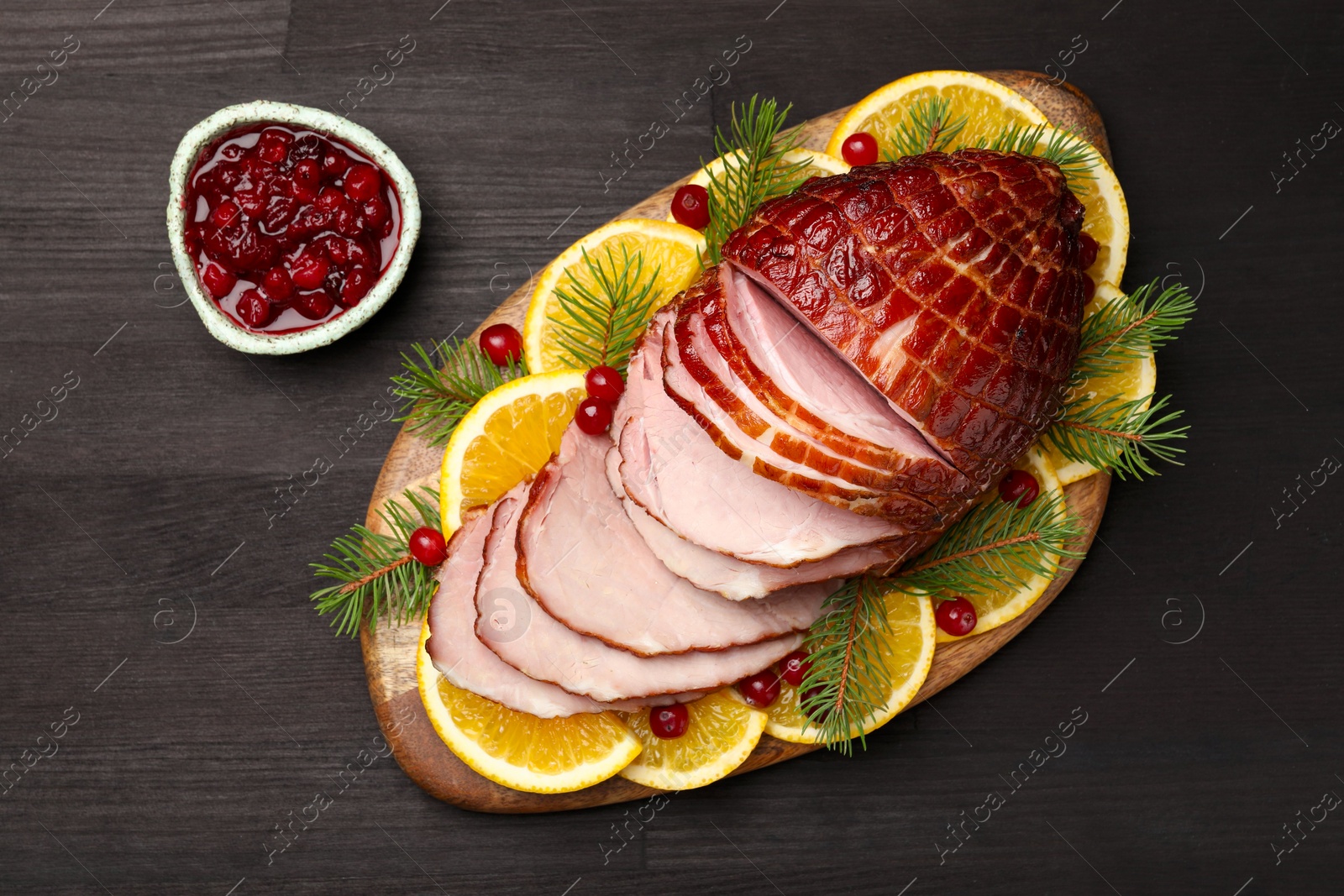 Photo of Tasty baked ham served on black wooden table, flat lay