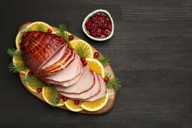 Photo of Tasty baked ham served on black wooden table, flat lay. Space for text