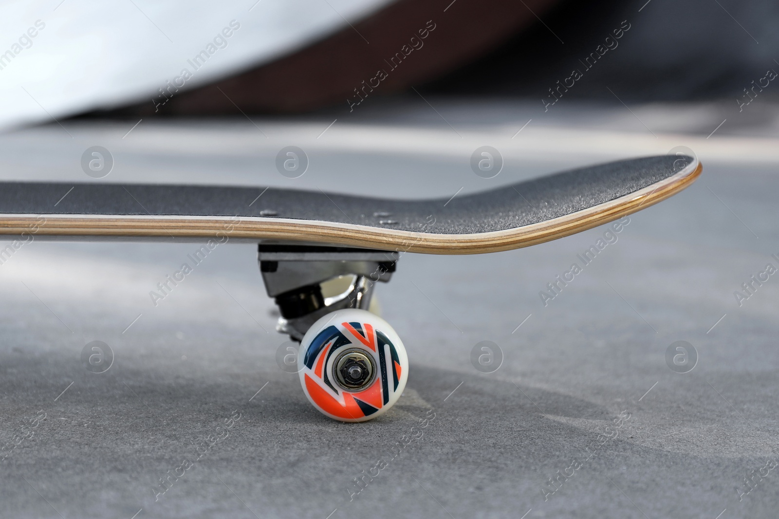 Photo of One modern skateboard on ground outdoors, closeup