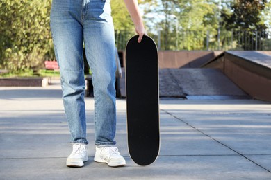 Photo of Woman with modern skateboard in skatepark, closeup. Space for text