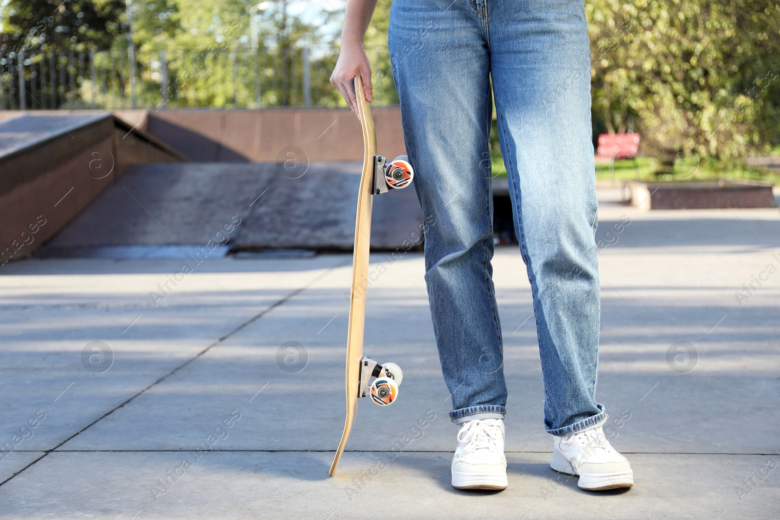 Photo of Woman with modern skateboard in skatepark, closeup. Space for text