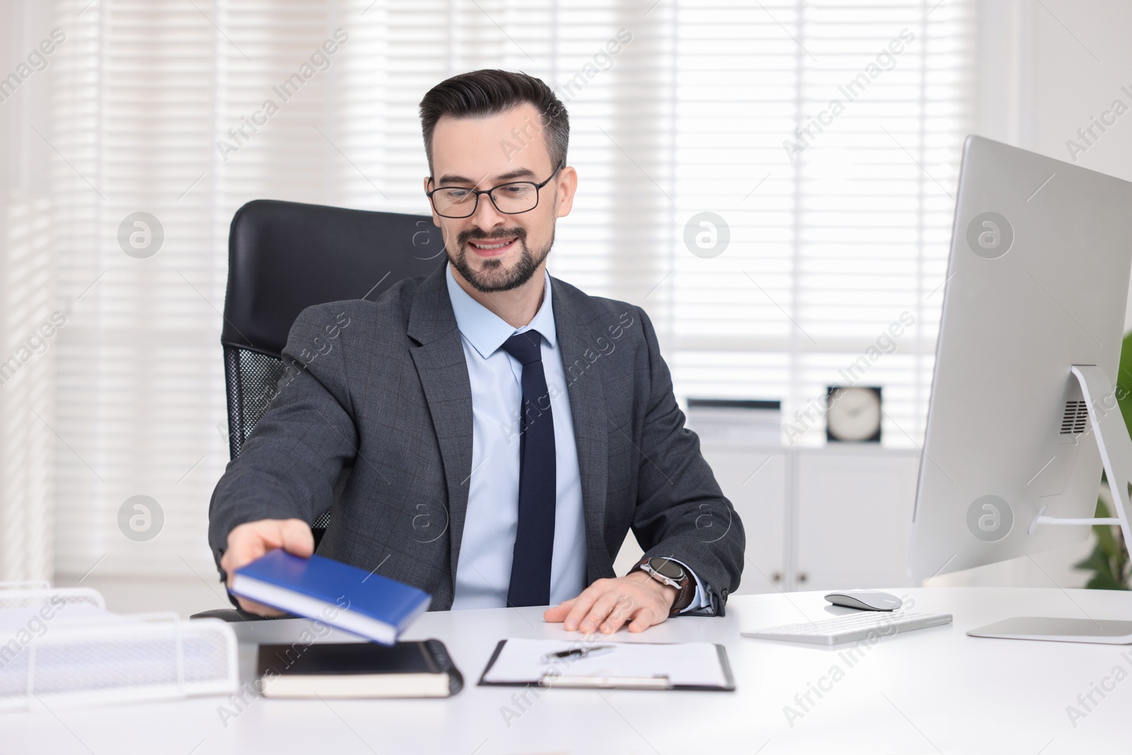 Photo of Smiling banker working at table in office